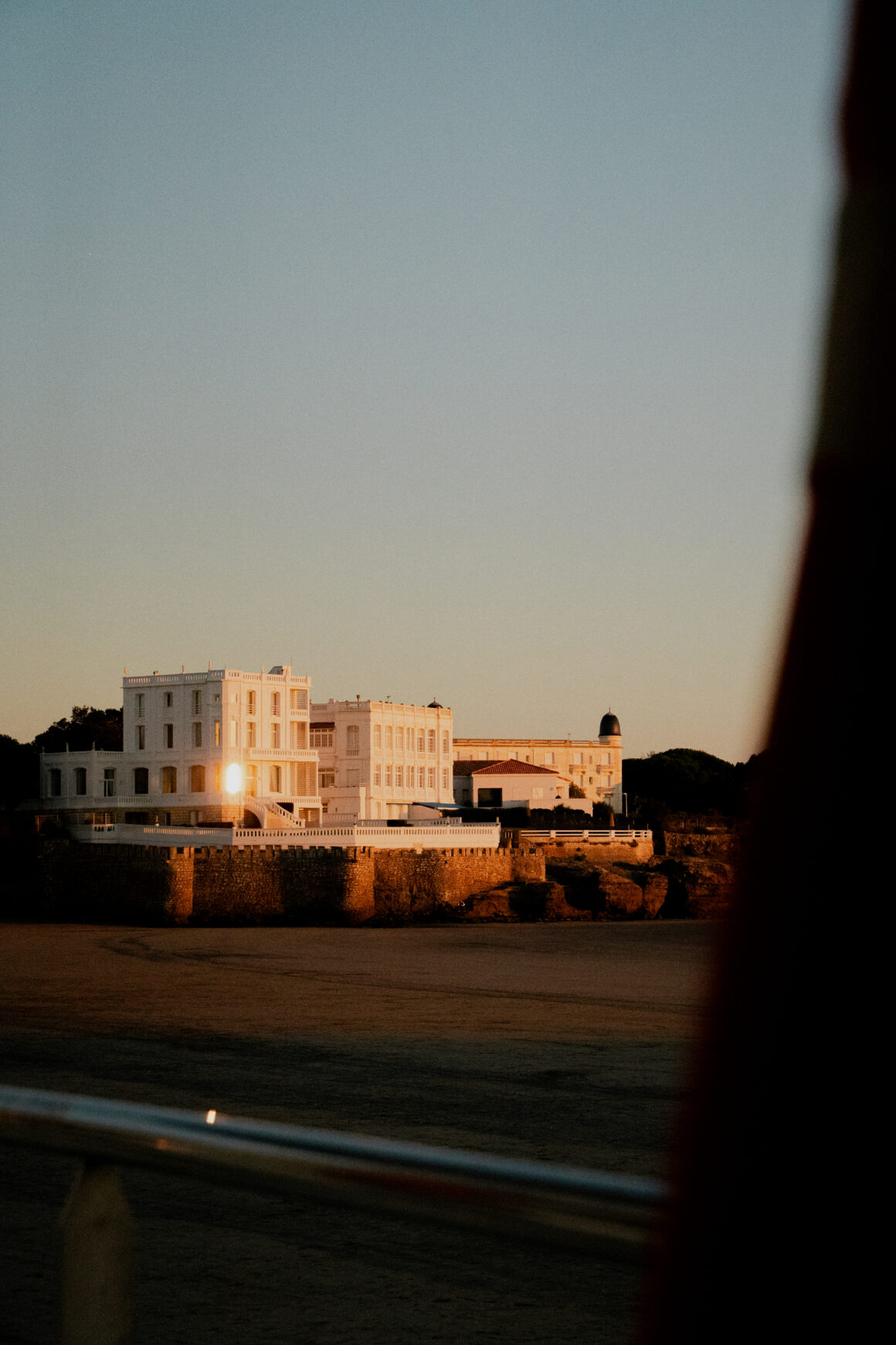 Photographe d'architecture pour hôtel haut de gamme en bord de mer, ambiance de fin de journée, façade blanche et pierre.
