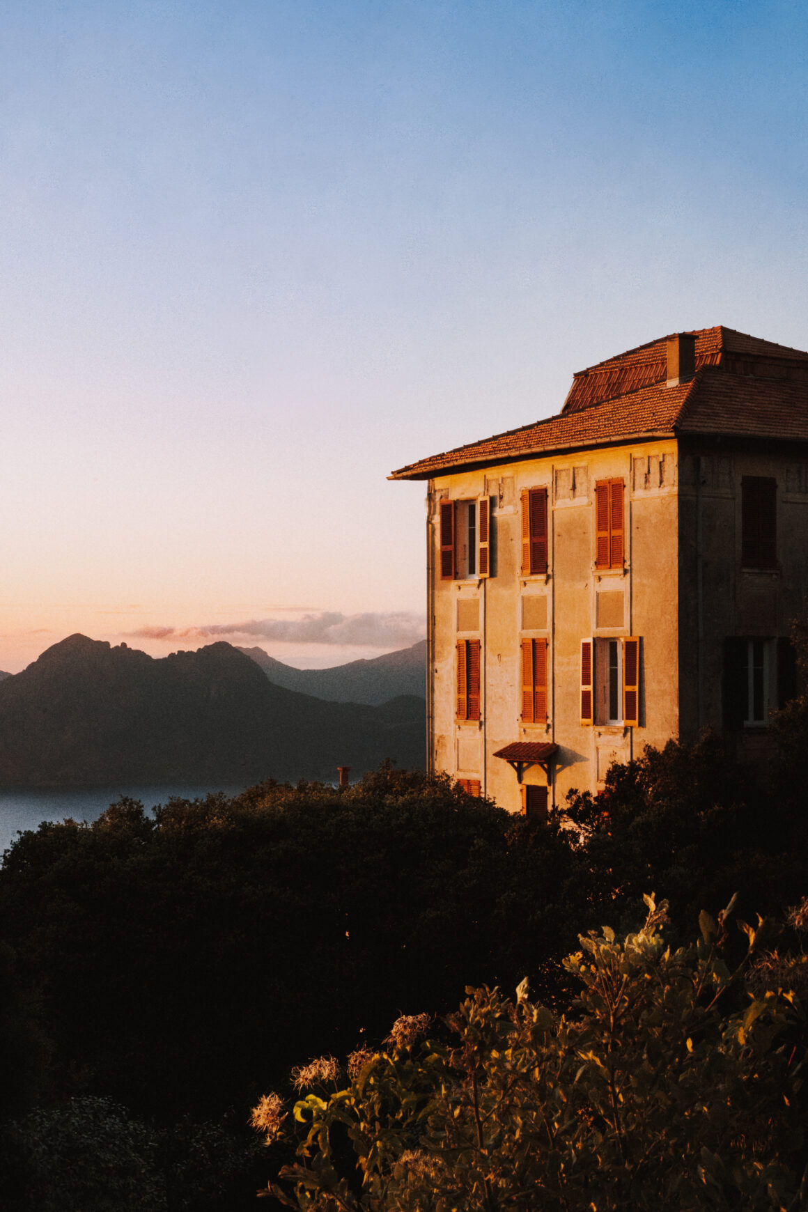 Photographe d'architecture et d'hôtel en Corse, vue de la façade de l'Hôtel Les Roches Rouges à Piana durant la golden hour.