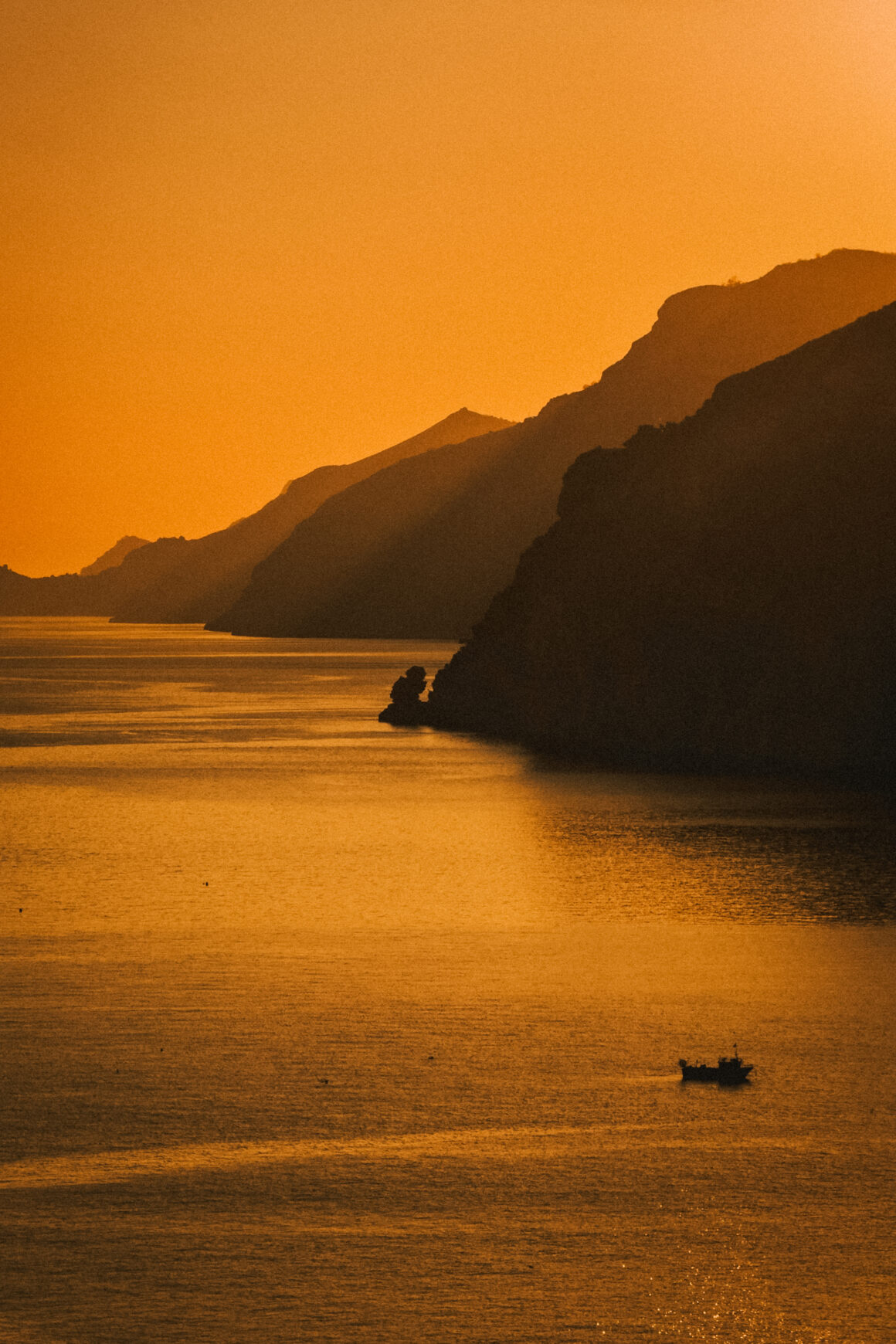 Photographie d'art de la Côte Amalfitaine en Italie à l'heure dorée, silhouettes de falaises et mer Méditerranée.