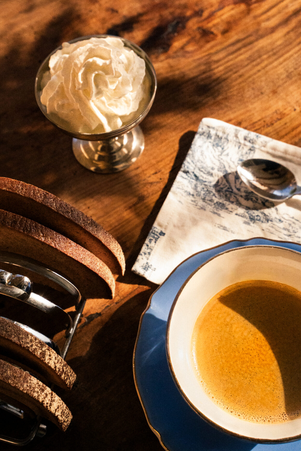 Photographie d'un petit déjeuner dans un hôtel en bord de mer, café à la lumière du matin, ambiance chaleureuse méditerranéenne