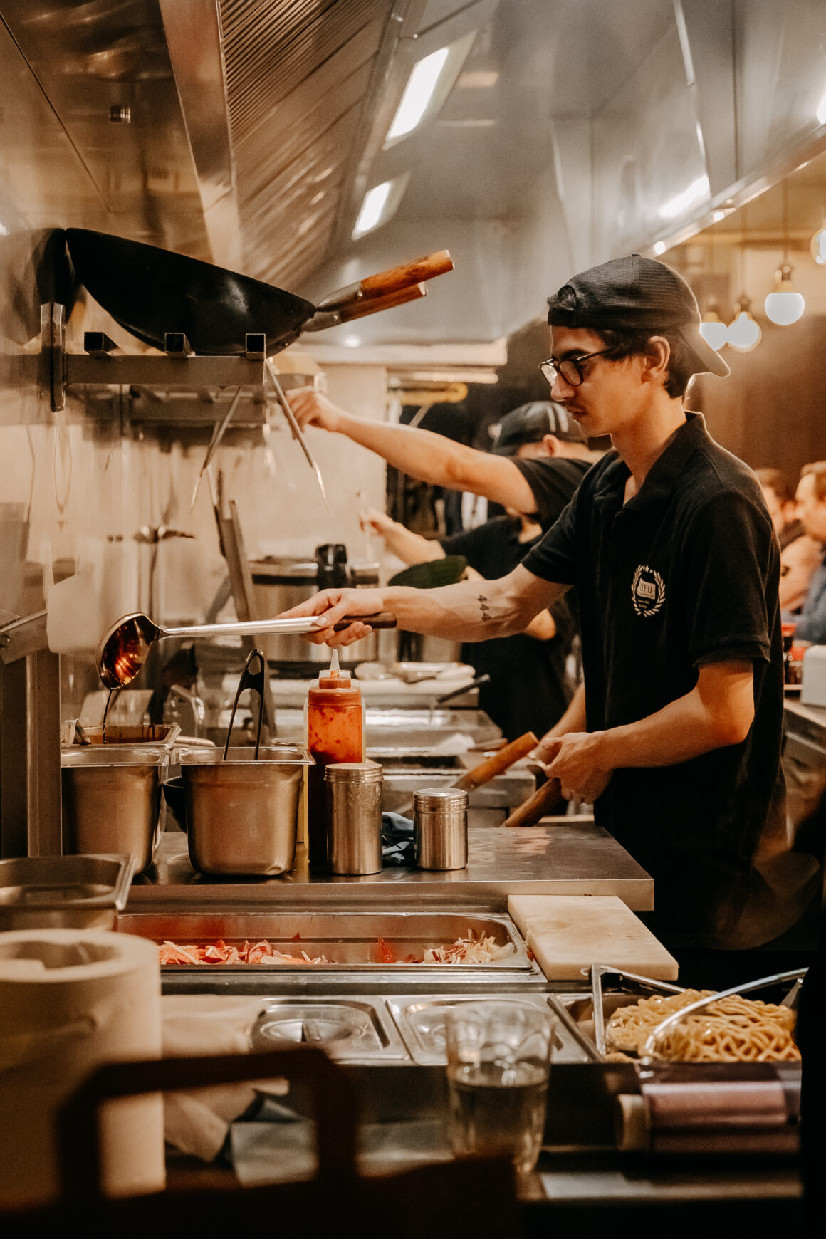 Cuisinier servant un plat dans la cuisine de FUFU Ramen à Bordeaux