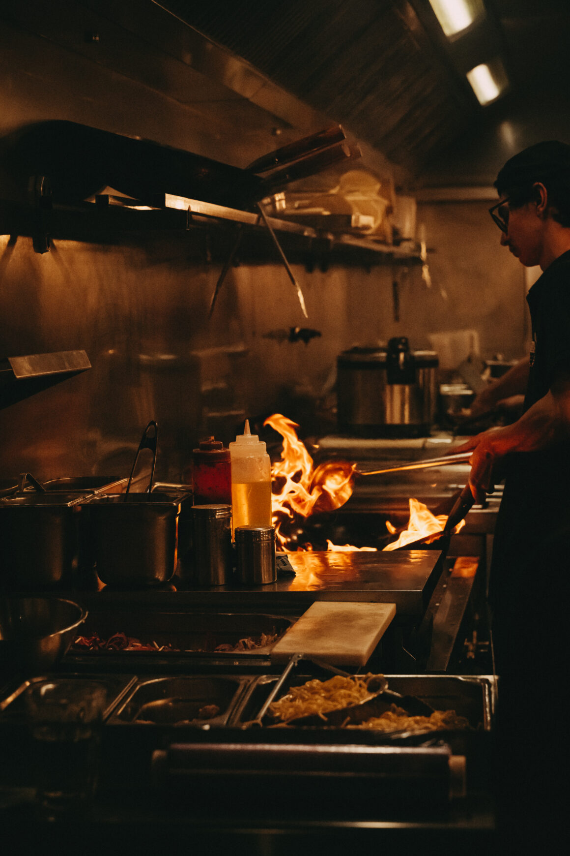 Cuisinier travaillant à la flamme dans la cuisine de FUFU Ramen à Bordeaux