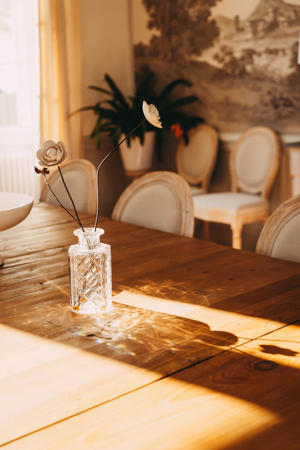 Vase en cristal et fleurs décoratives sur la table en bois de la salle à manger du Château Larteau, près de Bordeaux.