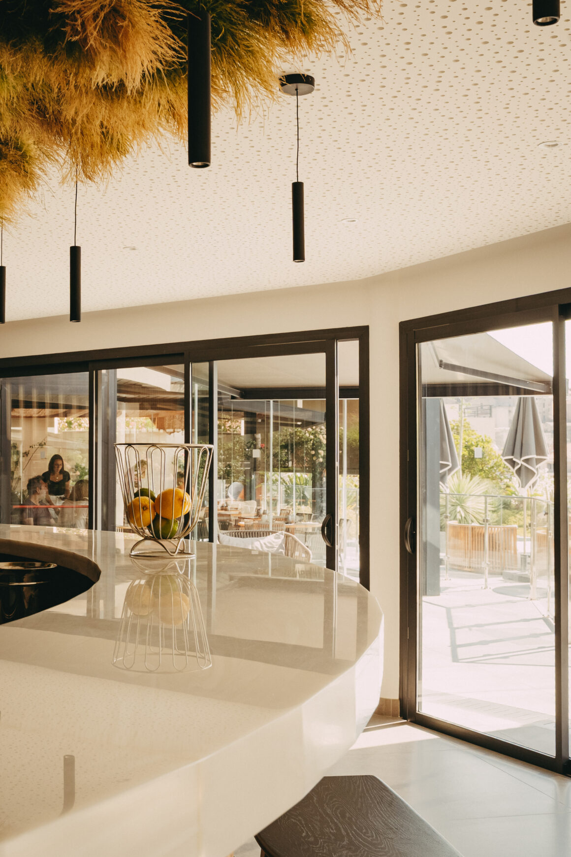 Espace intérieur lumineux d’un hôtel à Calvi avec comptoir et ouverture sur la terrasse