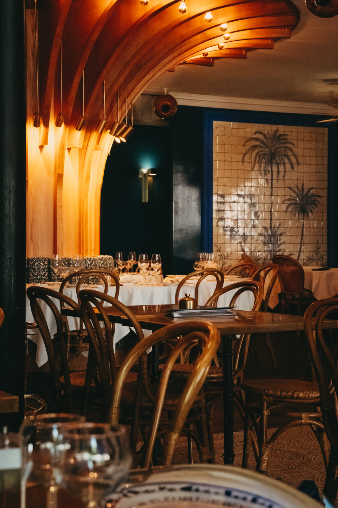 Salle du Grand Café des Fleurs à Nice avec arches en bois et fresque aux palmiers