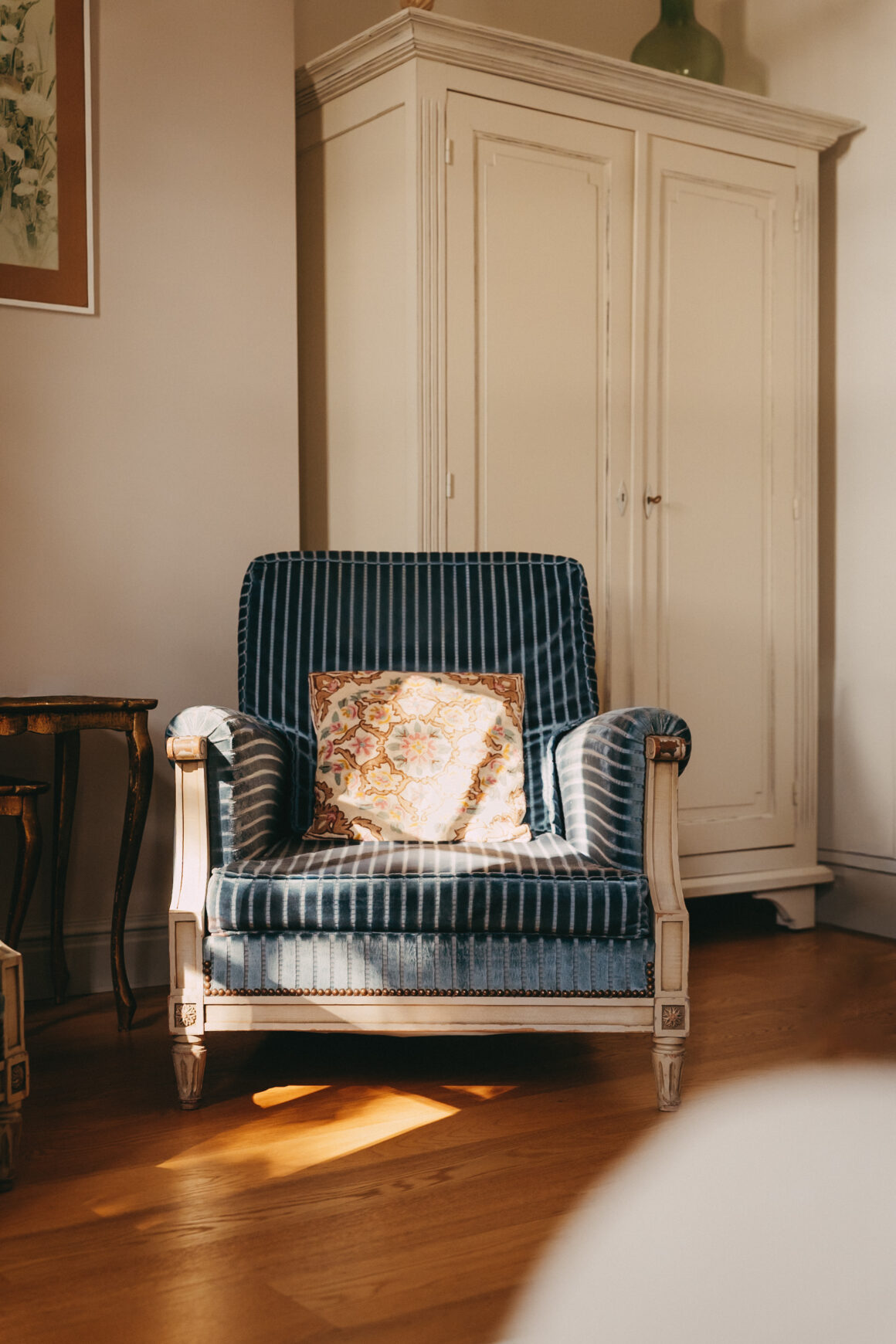 Fauteuil ancien en velours bleu dans un intérieur du Château Larteau en Gironde.