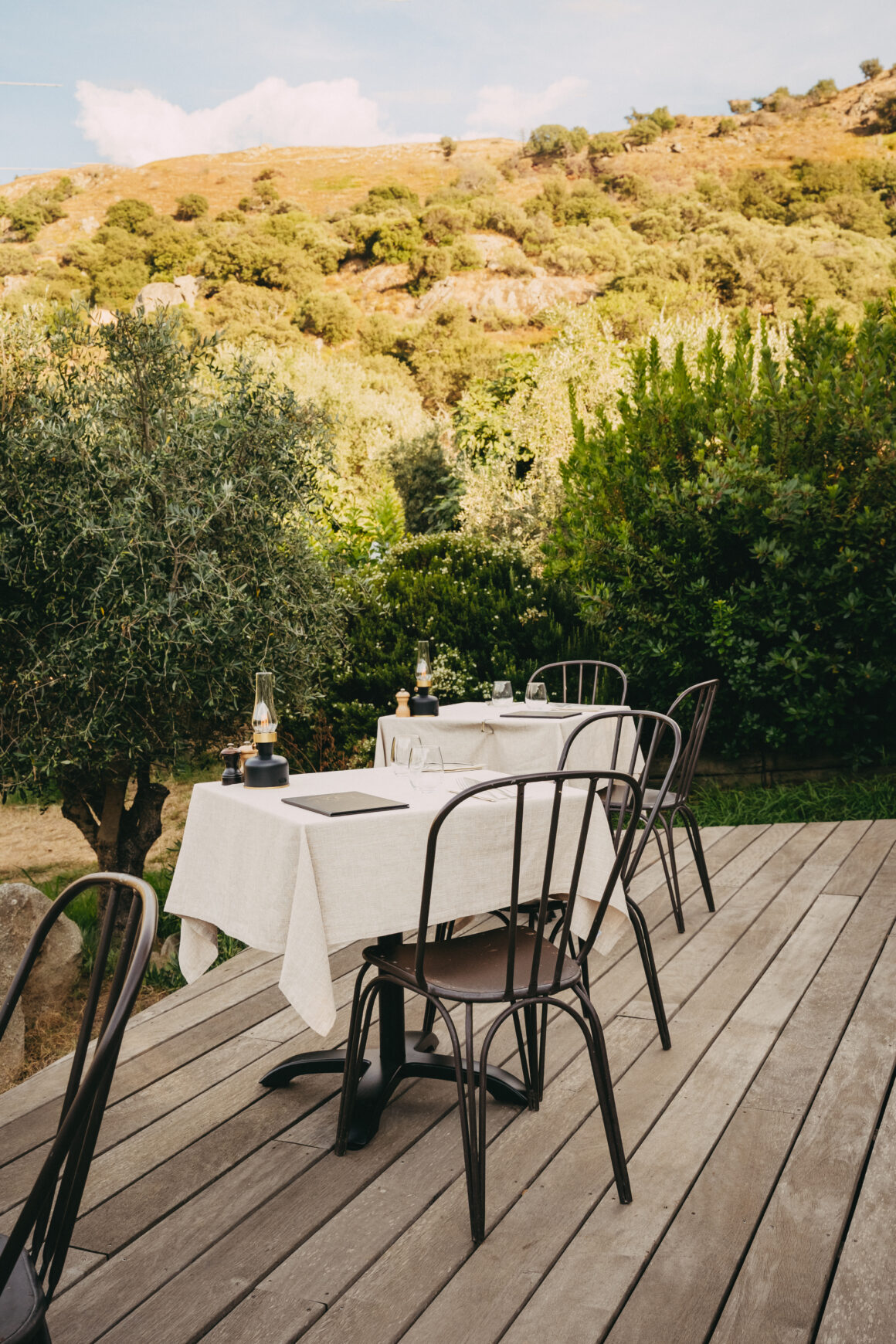 Tables dressées sur la terrasse d’A Mandria di Pigna au cœur de la végétation en Balagne
