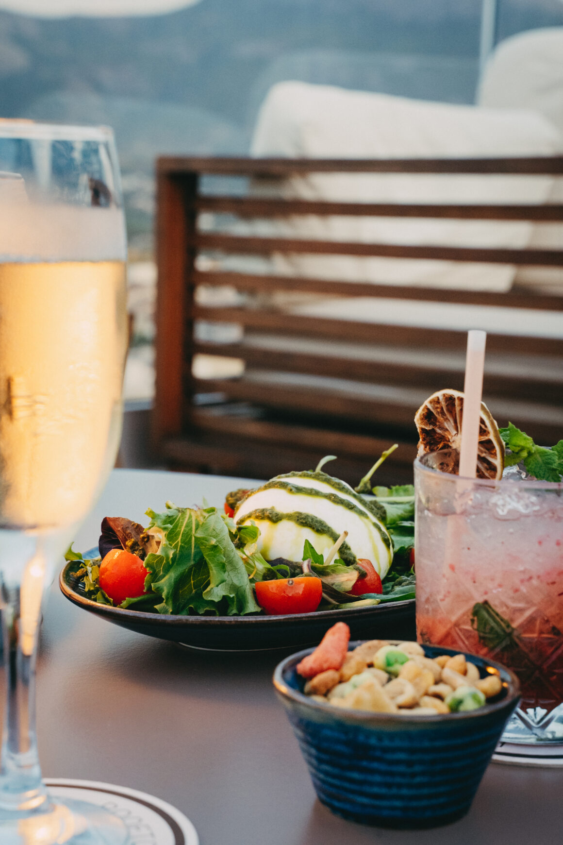 Assiette et cocktail servis sur la terrasse d’un hôtel à Calvi