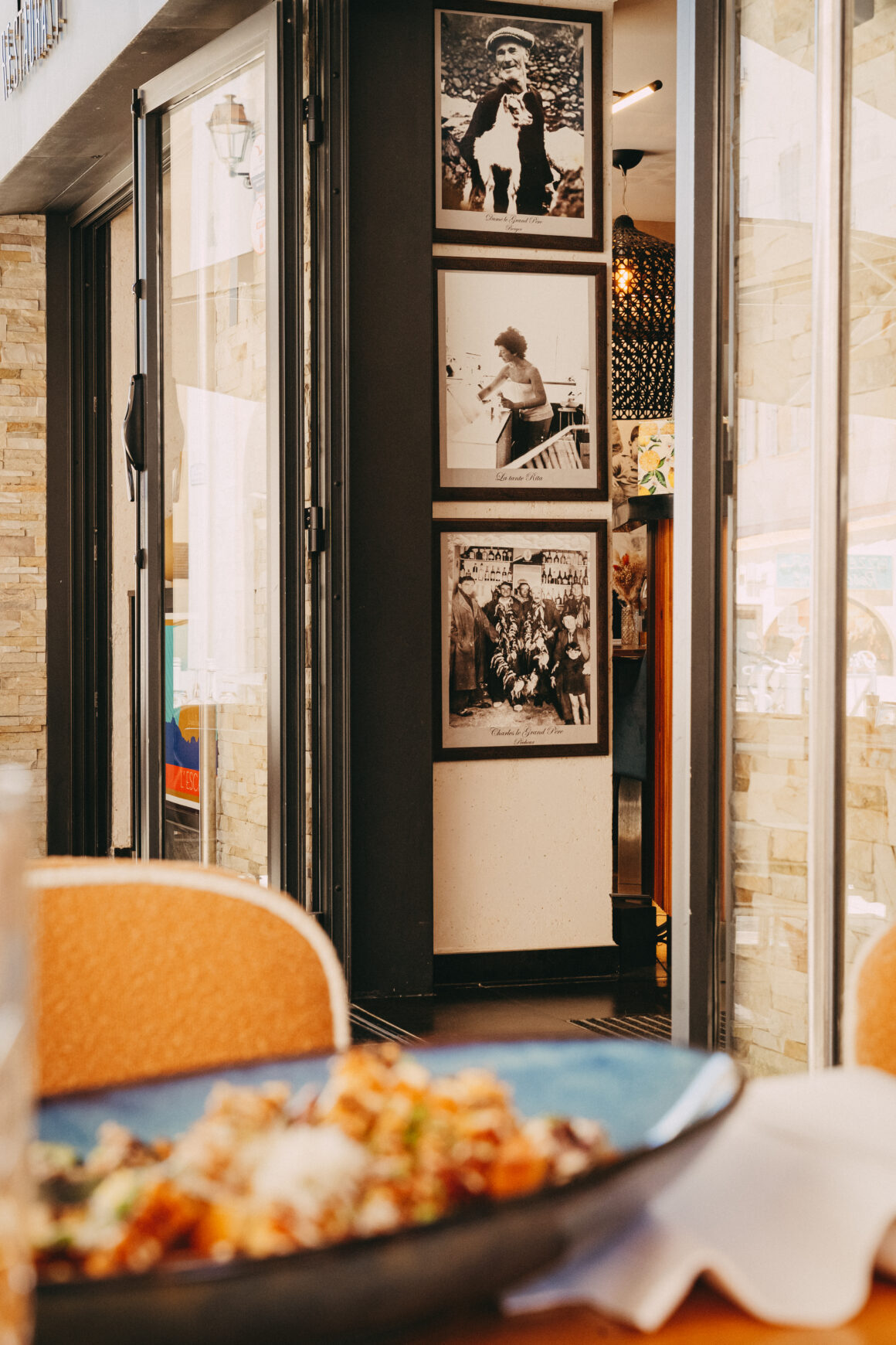Intérieur du restaurant L’Escale à L’Île-Rousse avec assiette au premier plan