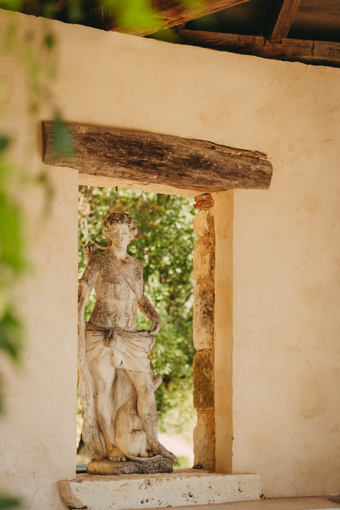 Statue d’un chasseur mythologique possiblement Adonis ou Méléagre accompagné d’un chien, dans une ouverture en pierre au Domaine de Lavernelle.