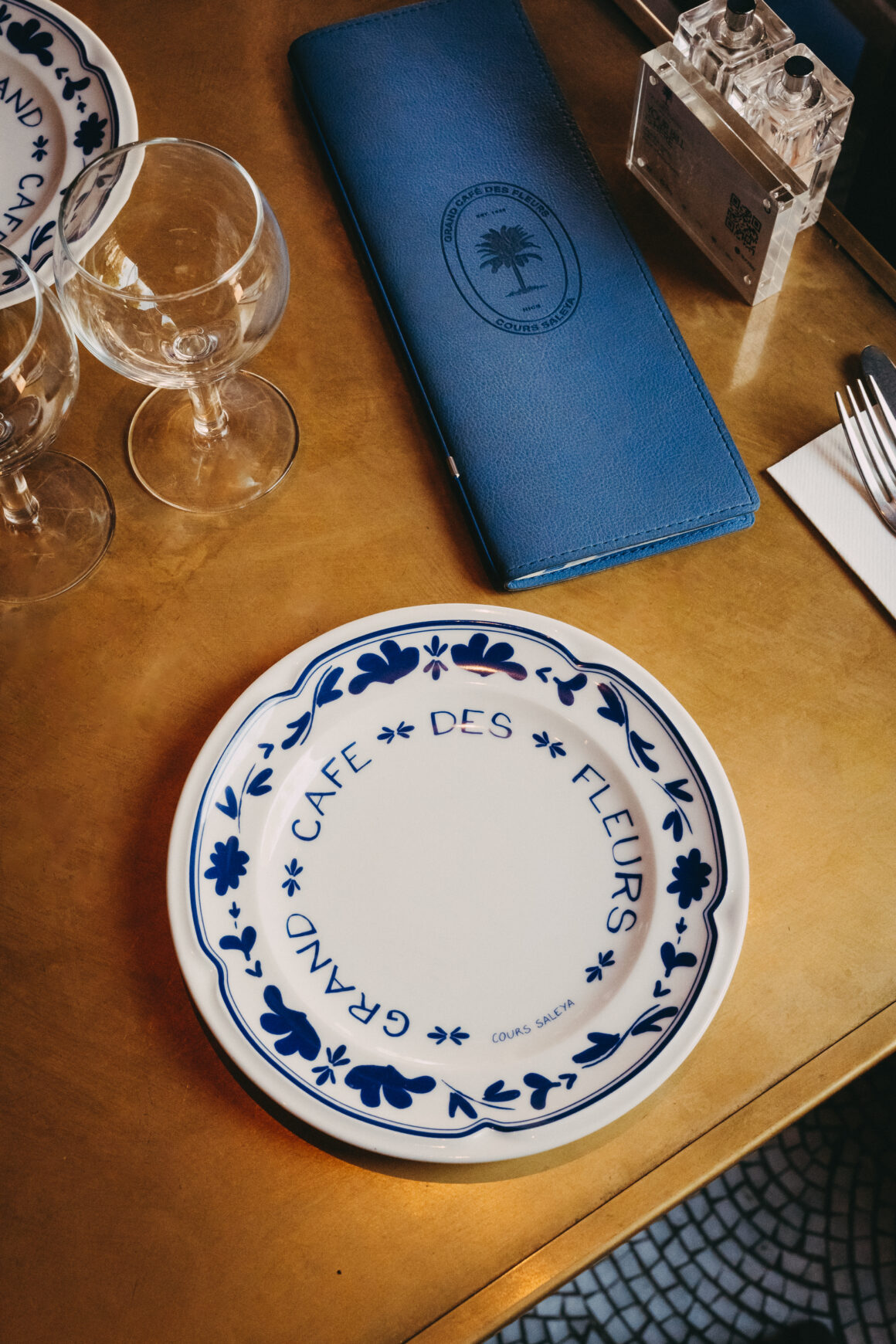 Assiette et menu du Grand Café des Fleurs sur une table de restaurant à Paris